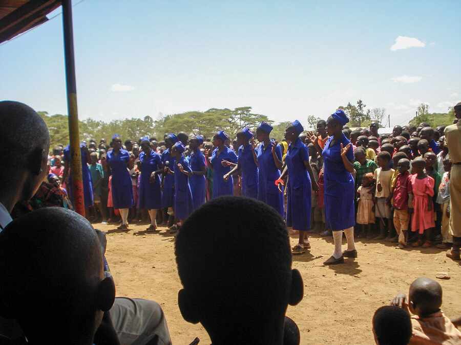 Learners performing before community members and programme partners.