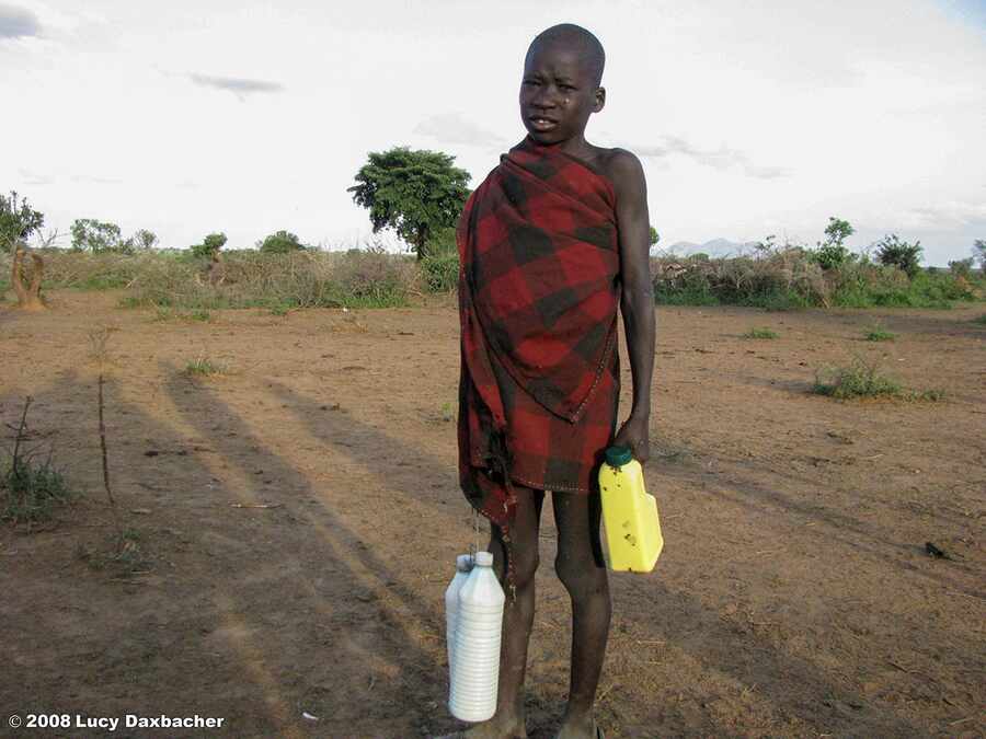 A Karimojong child carrying fresh milk home from a kraal.